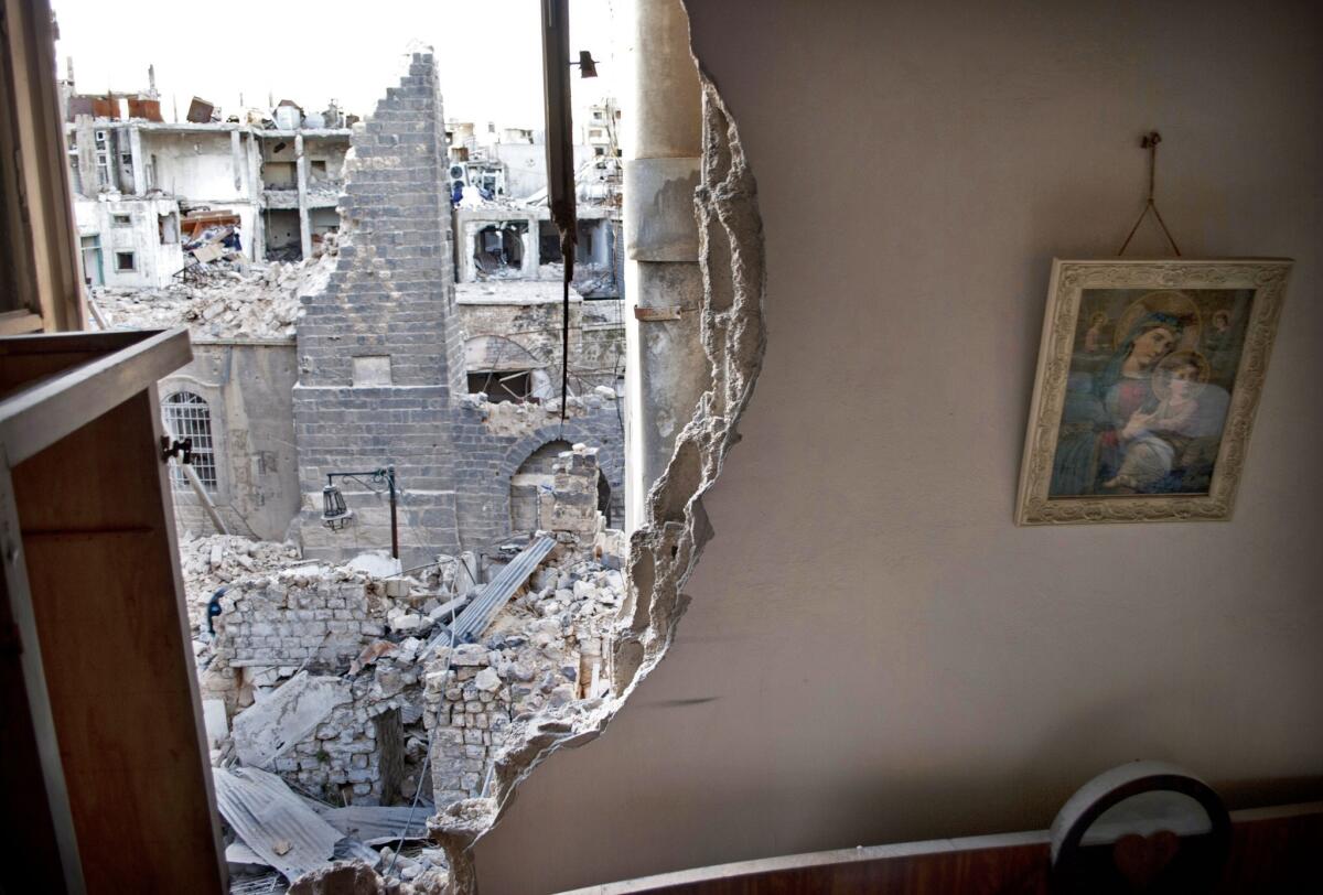 An image of the Virgin Mary and an infant Jesus hangs on the partially destroyed wall of a house belonging to a Christian family in a neighborhood besieged by government forces in the Syrian city of Homs.