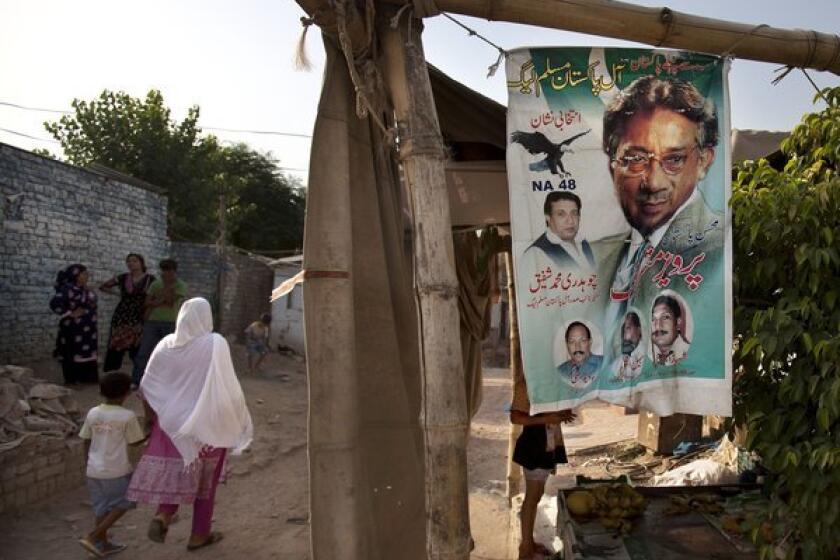 A woman walks past an election banner for Pakistan's former military ruler, Pervez Musharraf, in a neighborhood of Islamabad.