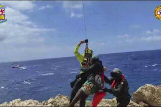In this picture taken from video distributed on Sunday, Aug. 6, 2023 by the Italian Alpine Rescue squads, a migrant stranded on a rocky reef on the tiny Italian southern island of Lampedusa, Sicily is pluck to safety by helicopter. Dozens of migrants were dramatically rescued by Italy as they foundered in the sea or clung to a rocky reef Sunday after three boats launched by smugglers from northern Africa shipwrecked in rough waters in separate incidents over the weekend (Italian Alpine Rescue via AP)