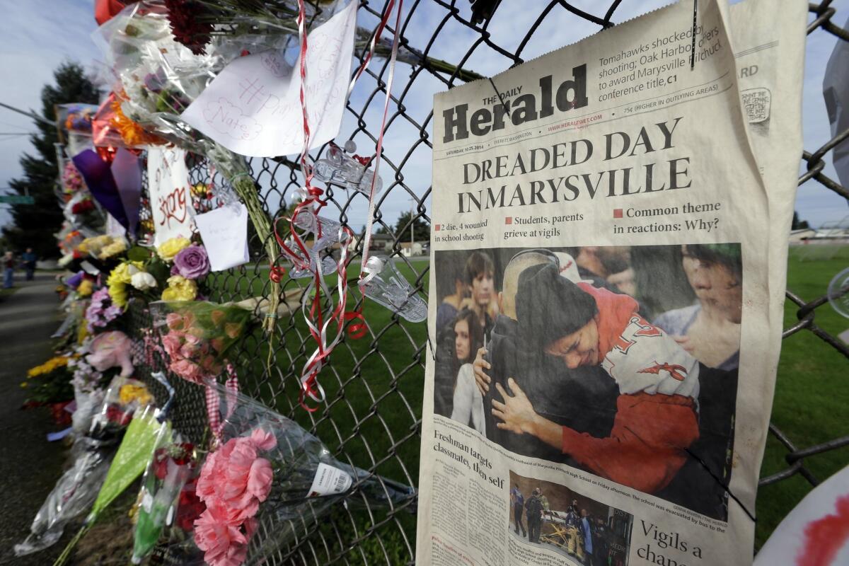 An edition of The Daily Herald from Everett, Wash., is shown as part of a growing memorial on a fence around Marysville-Pilchuck High School in October.