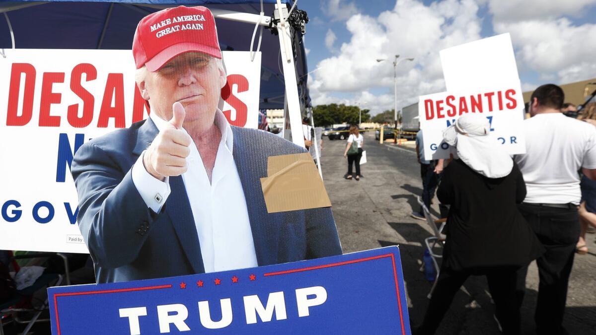 A cutout of President Trump stands in a demonstrator area outside the Broward County election headquarters.