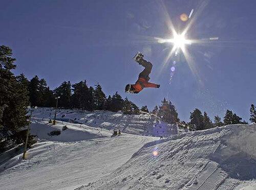 A snowboarder flips over the excellent conditions at Mountain High.