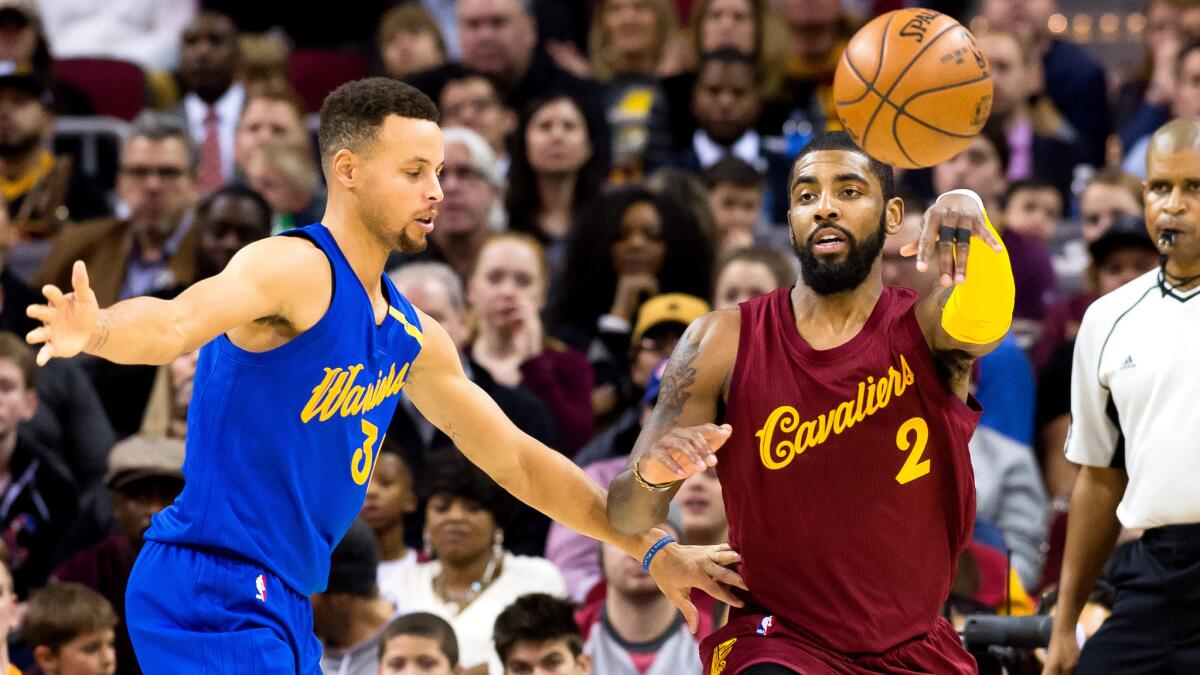 Cavaliers point guard Kyrie Irving (2) flips a pass from the corner as he's defended by Warriors point guard Stephen Curry during the first half Sunday.