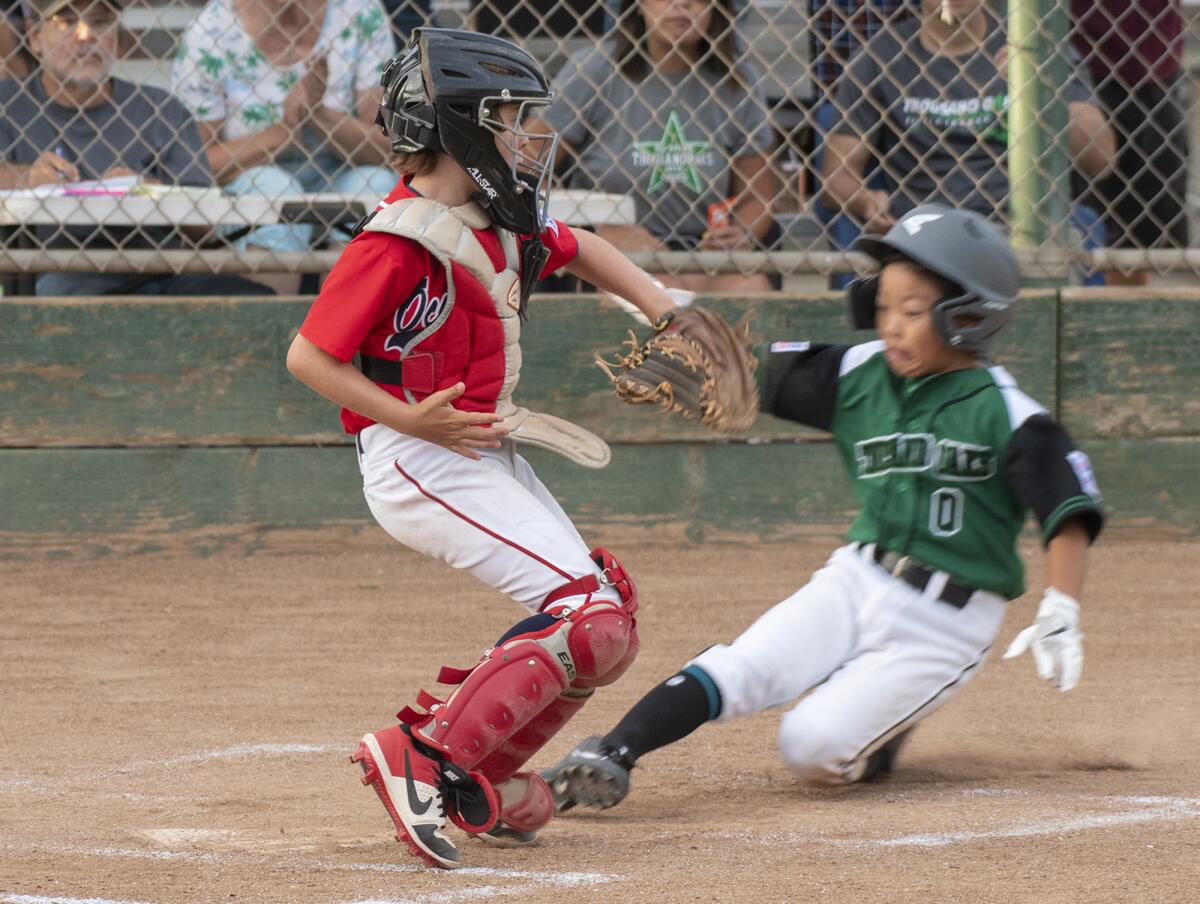 Thousand Oaks Little League's Prestron Lee beats the throw at home to Ocean View Little League's Dane Goodwin and scores a run in the second inning of the Southern California state tournament on Wednesday at Stearns Champions Park in Long Beach.