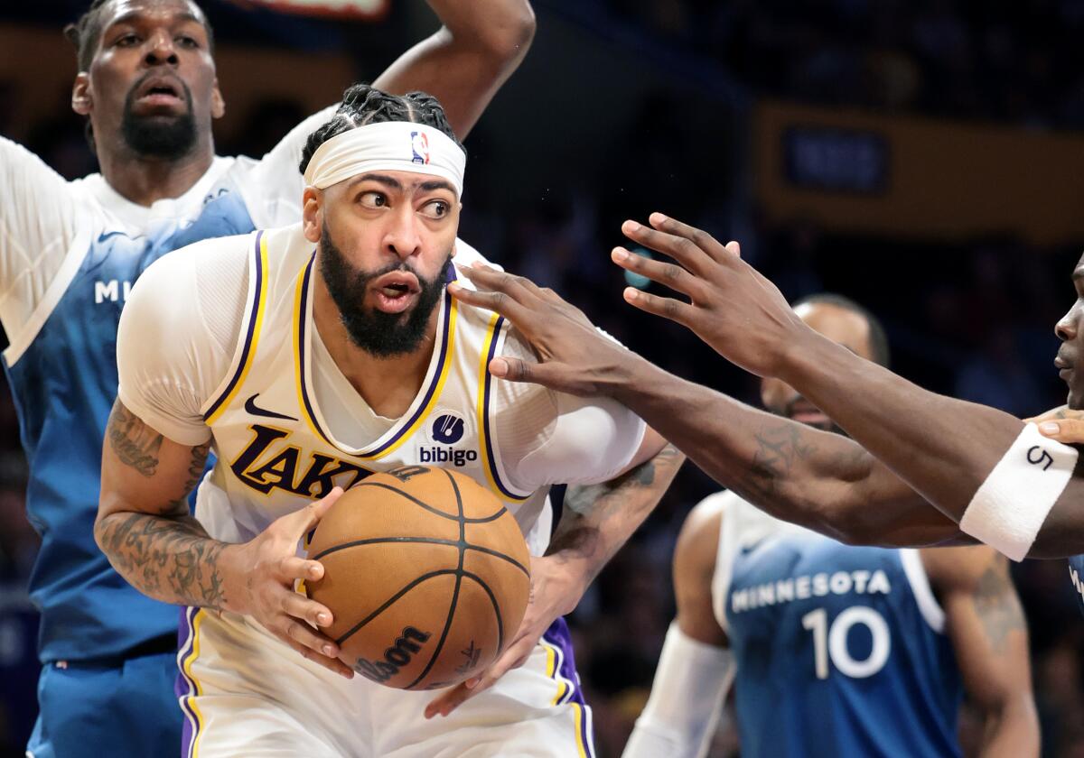 Lakers forward Anthony Davis tries to power his way past Minnesota defenders in the low post.