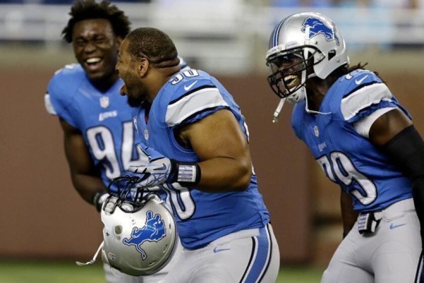 Detroit Lions defensive end Ezekiel Ansah (94), defensive tackle Ndamukong Suh (90) and defensive end Willie Young (79) share a laugh as they warm up for Sunday's game against the Vikings.