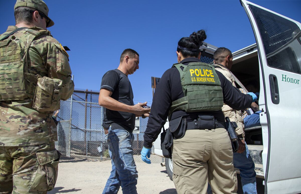 Migrants are loaded into a van after entering into El Paso from Ciudad Juarez, Mexico