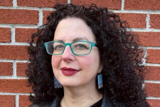 Emily Nussbaum, with curly brown hair and blue-frame glasses, stands in front of a brick wall.