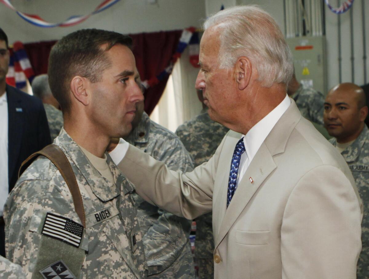 In this July 4, 2009, file photo, Vice President Joe Biden talks with his son, U.S. Army Capt. Beau Biden, at Camp Victory on the outskirts of Baghdad, Iraq.