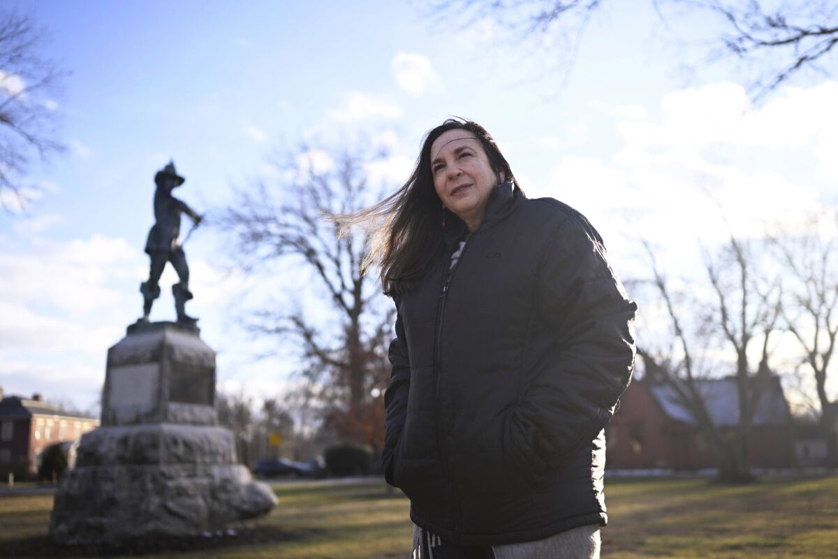 In this Tuesday, Jan. 24, 2023 photo, Beth Caruso, author and co-founder of the CT Witch Trial Exoneration Project, which was created to clear the names of the accused, stands on the Palisado Green in Windsor, Conn., where in 1651, an accident during a local militiamen training exercise led to the accusation of witchcraft and hanging of Lydia Gilbert. Now, more than 375 years later, amateur historians, researchers and descendants of the accused witches and their accusers, from across the U.S., are urging Connecticut officials to officially acknowledge this dark period of the state's colonial history and posthumously exonerate those wrongfully accused and punished. (AP Photo/Jessica Hill)