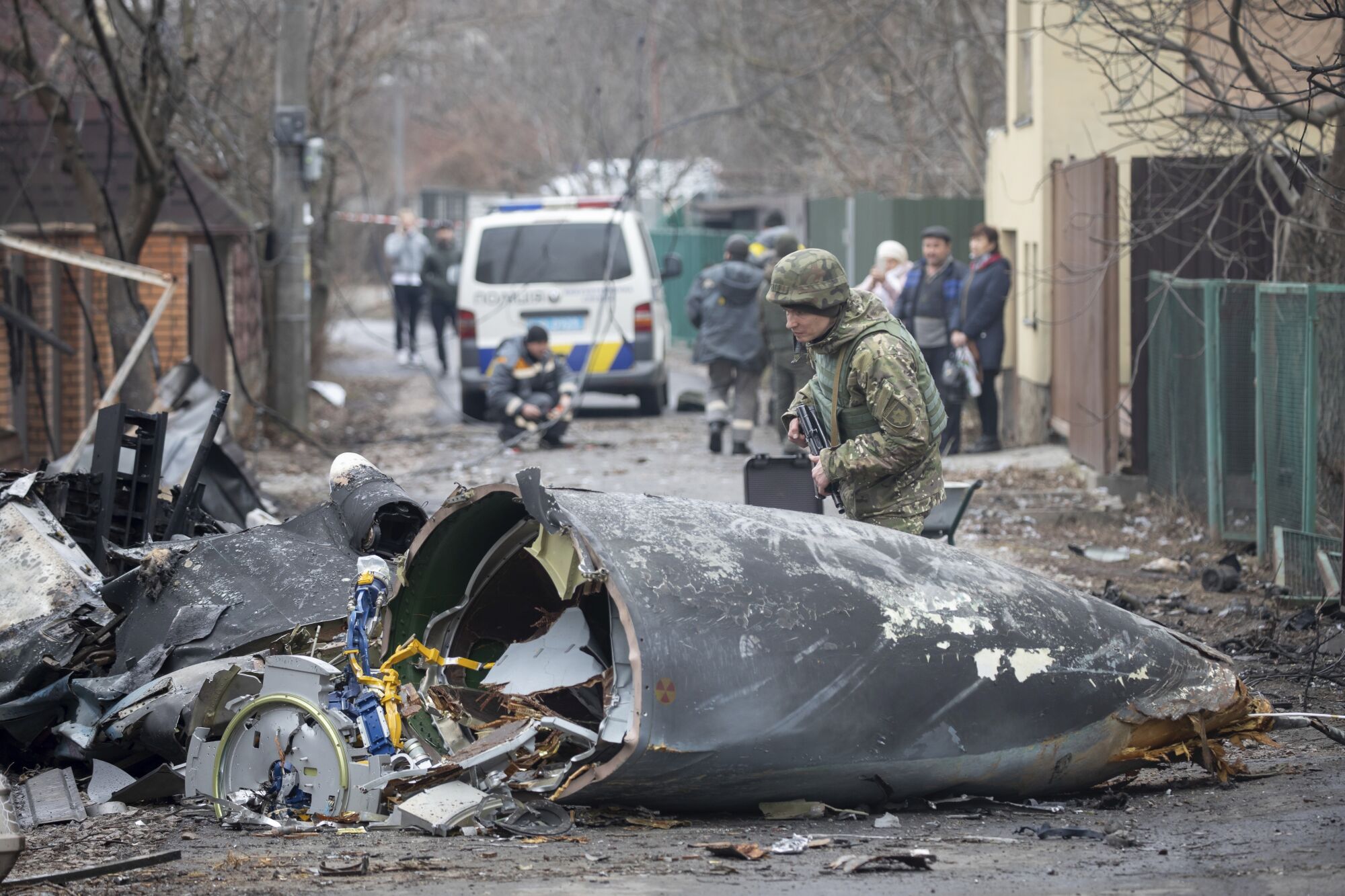 A Ukrainian soldier inspects the wreckage of a downed plane.