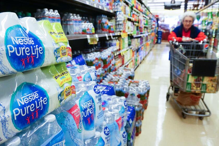 A woman pushes her shopping cart down the bottled water aisle at a supermarket in Los Angeles, California on March 15, 2018. The world's leading brands of bottled water are contaminated with tiny plastic particles that are likely seeping in during the packaging process, according to a major study across nine countries. Plastic was identified in 93 percent of the samples, which included major name brands such as Aqua, Aquafina, Dasani, Evian, Nestle Pure Life and San Pellegrino. / AFP PHOTO / FREDERIC J. BROWN (Photo credit should read FREDERIC J. BROWN/AFP via Getty Images)