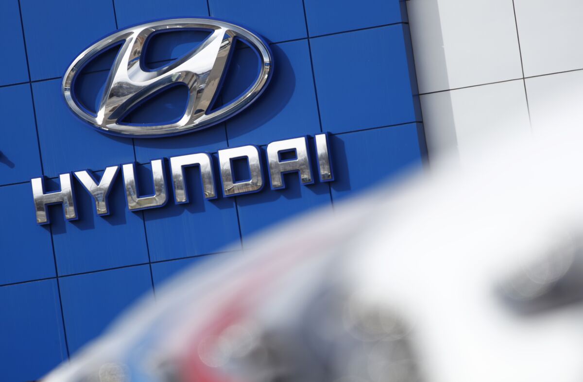 FILE- In this April 15, 2018, file photo, the company logo hangs on the side of a showroom at a Hyundai dealer in Littleton, Colo. The National Highway Traffic Safety Administration's Office of Defects Investigation has opened a query into seat belt pretensioners on certain 2020-2022 Kia/Hyundai vehicles, saying that they may rupture or explode. A seat belt pretensioner is a part of the seat belt system that locks the seat belt in place during a crash. (AP Photo/David Zalubowski, File)