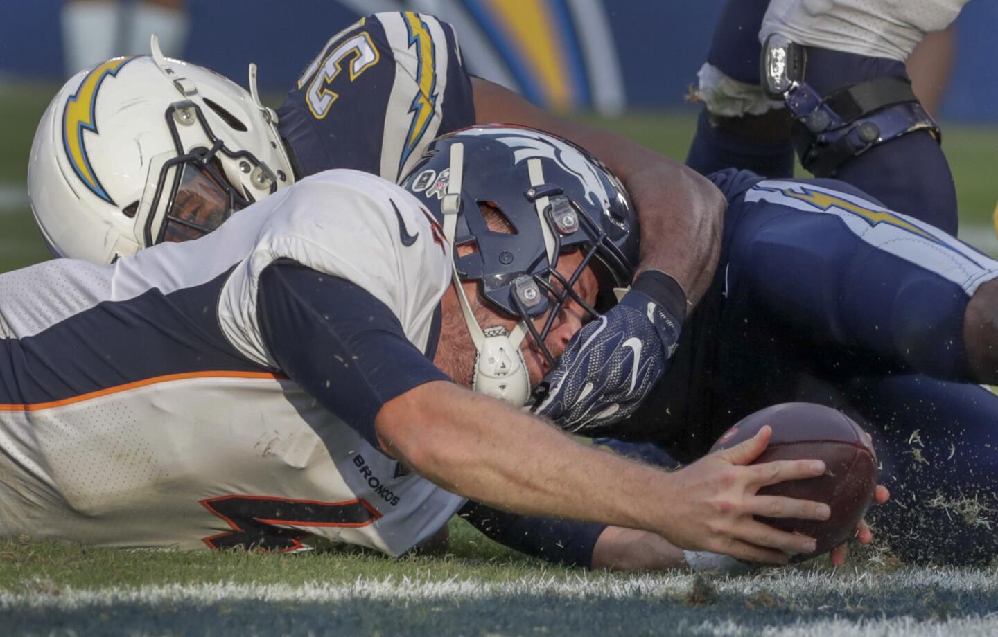 Denver Broncos quarterback Case Keenum is held short of a two-point conversion by Chargers safety Adrian Phillips during fourth quarter action at Stubhub Center.