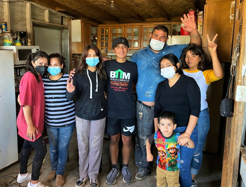 Daniella Benítez and Gabriel pose with a Tijuana family whose house they started to build 