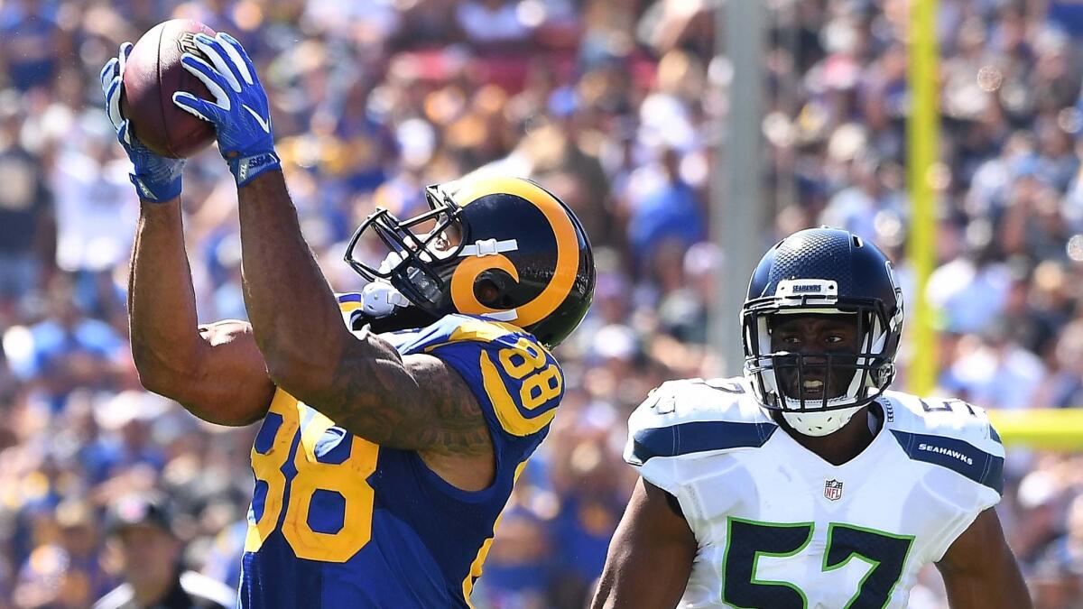The Rams' Lance Kendricks makes a catch in front of the Seahawks' Mike Morgan during the second quarter of a Sept. 18 game at the Coliseum.