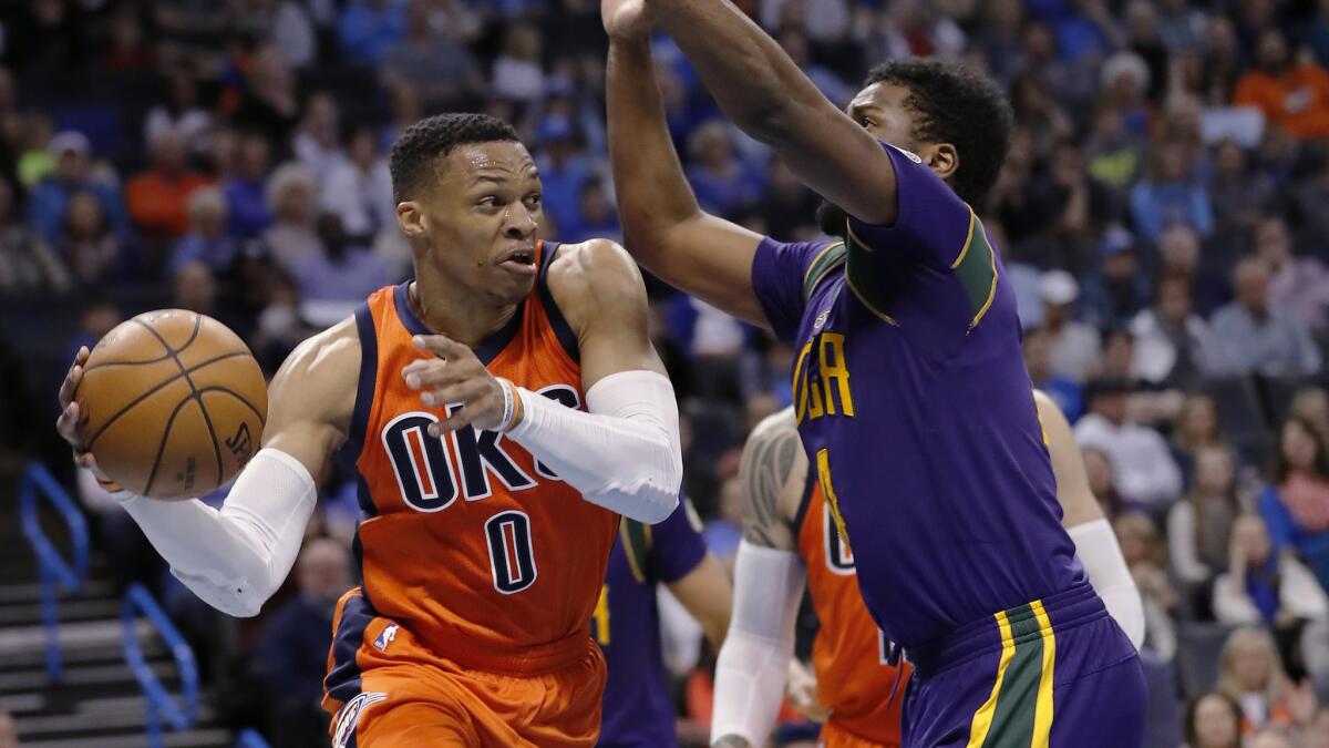 Thunder guard Russell Westbrook (0) passes the ball around Pelicans forward Solomon Hill after driving the baseline during the second half Sunday.