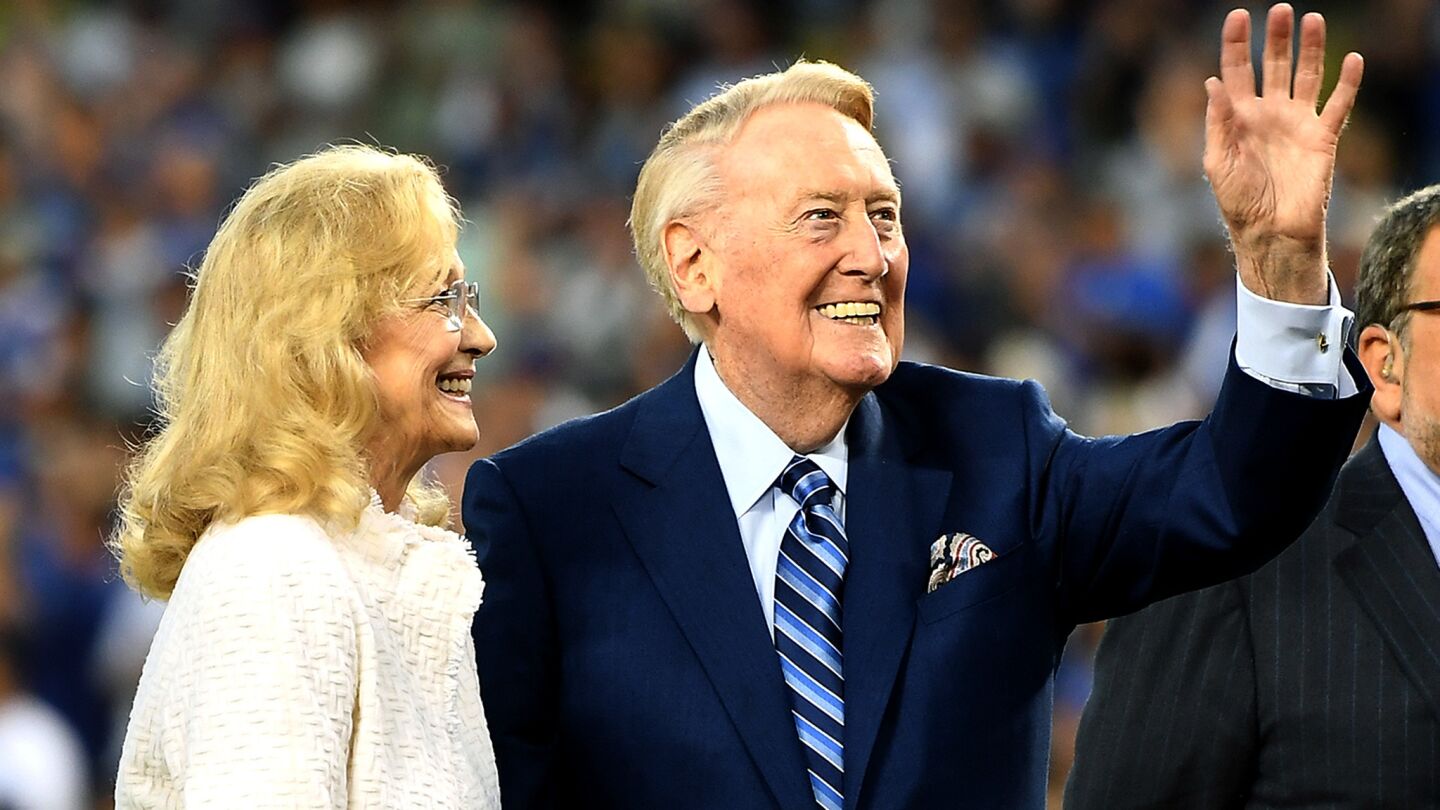 Vin Scully, with wife Sandi at his side, waves to the crowd during a ceremony honoring the Dodgers broadcaster before the game Sept. 23, 2016, at Dodger Stadium.