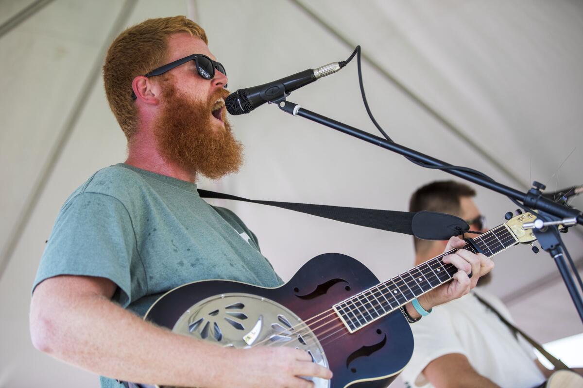 Singer-songwriter Oliver Anthony playing guitar and singing.