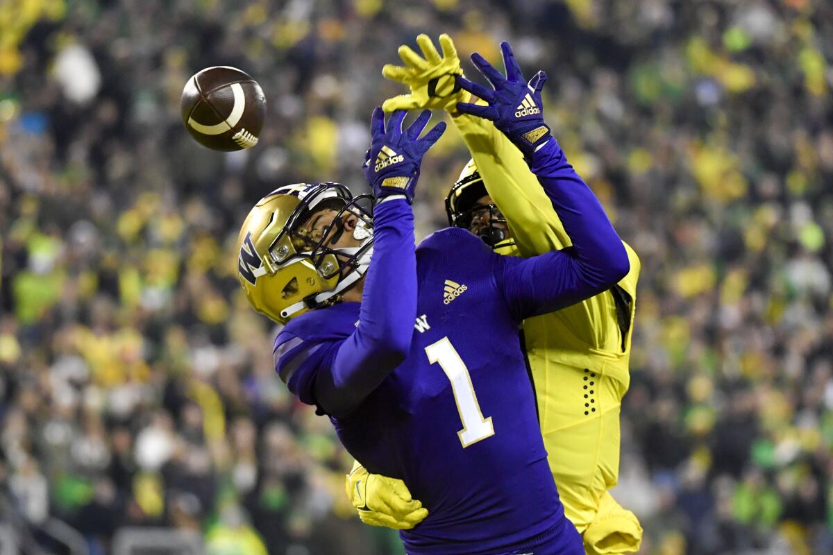 Oregon defensive back Bryan Addison breaks up a pass intended for Washington wide receiver Rome Odunze.