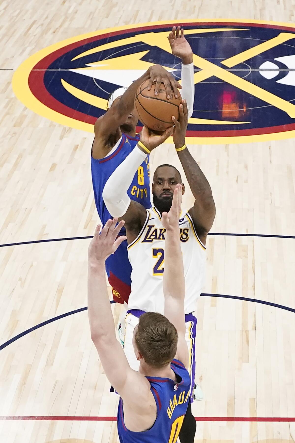 Nuggets forward Peyton Watson blocks a shot by Lakers forward LeBron James as guard Christian Braun applies pressure