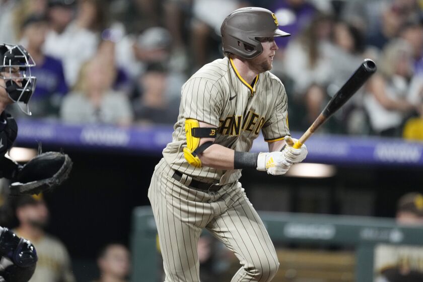 San Diego Padres' Jake Cronenworth follows the flight of his single to drive in two runs off Colorado Rockies relief pitcher Justin Lawrence in the seventh inning of a baseball game Saturday, Sept. 24, 2022, in Denver. (AP Photo/David Zalubowski)