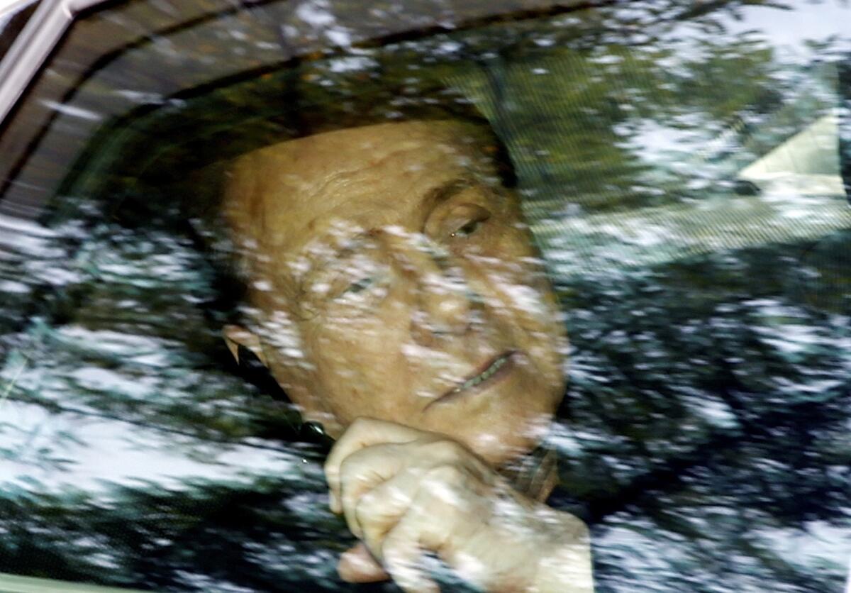 Silvio Berlusconi, former prime minister of Italy, talks on the phone as he leaves the 'Sacra Famiglia' institute in Cesano Boscone.