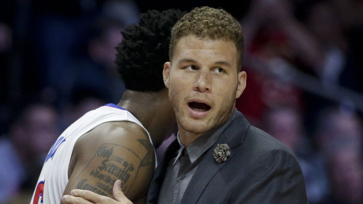 Injured Clippers forward Blake Griffin, right, hugs teammate DeAndre Jordan during the Clippers' loss to the Memphis Grizzlies on Monday.