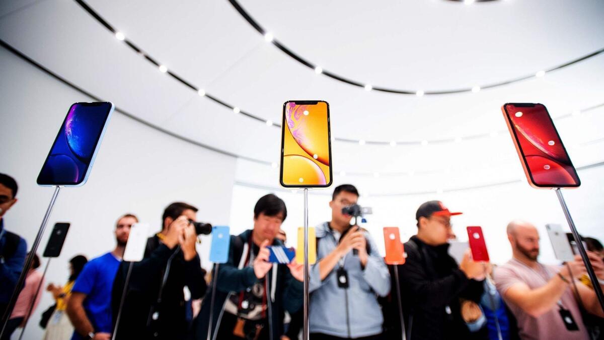 Apple iPhone XR models are displayed during a launch event in Cupertino, Calif. Apple’s operating profit last year was $71 billion. Hon Hai, which gets half its sales from Apple for assembling iPhones and other products, earned $4.5 billion.