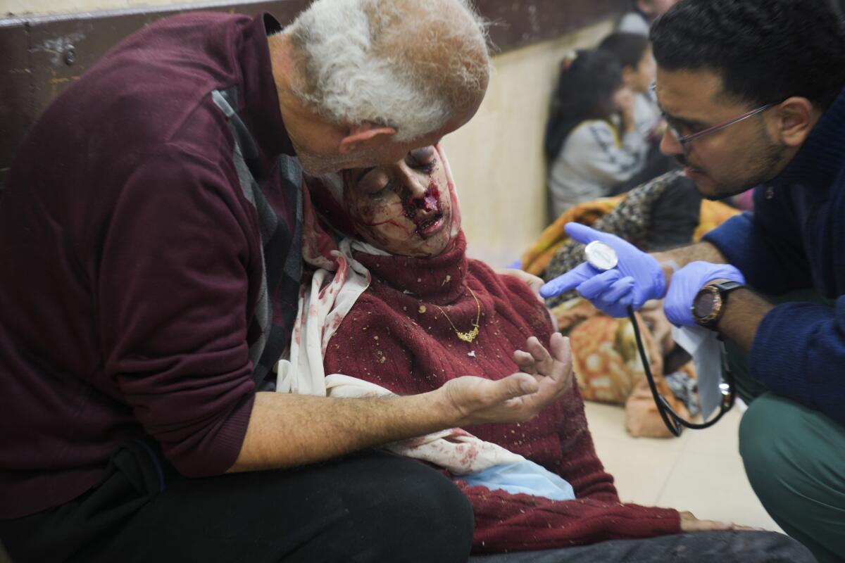 Palestinians wounded in Israeli bombardment are helped in a hospital.