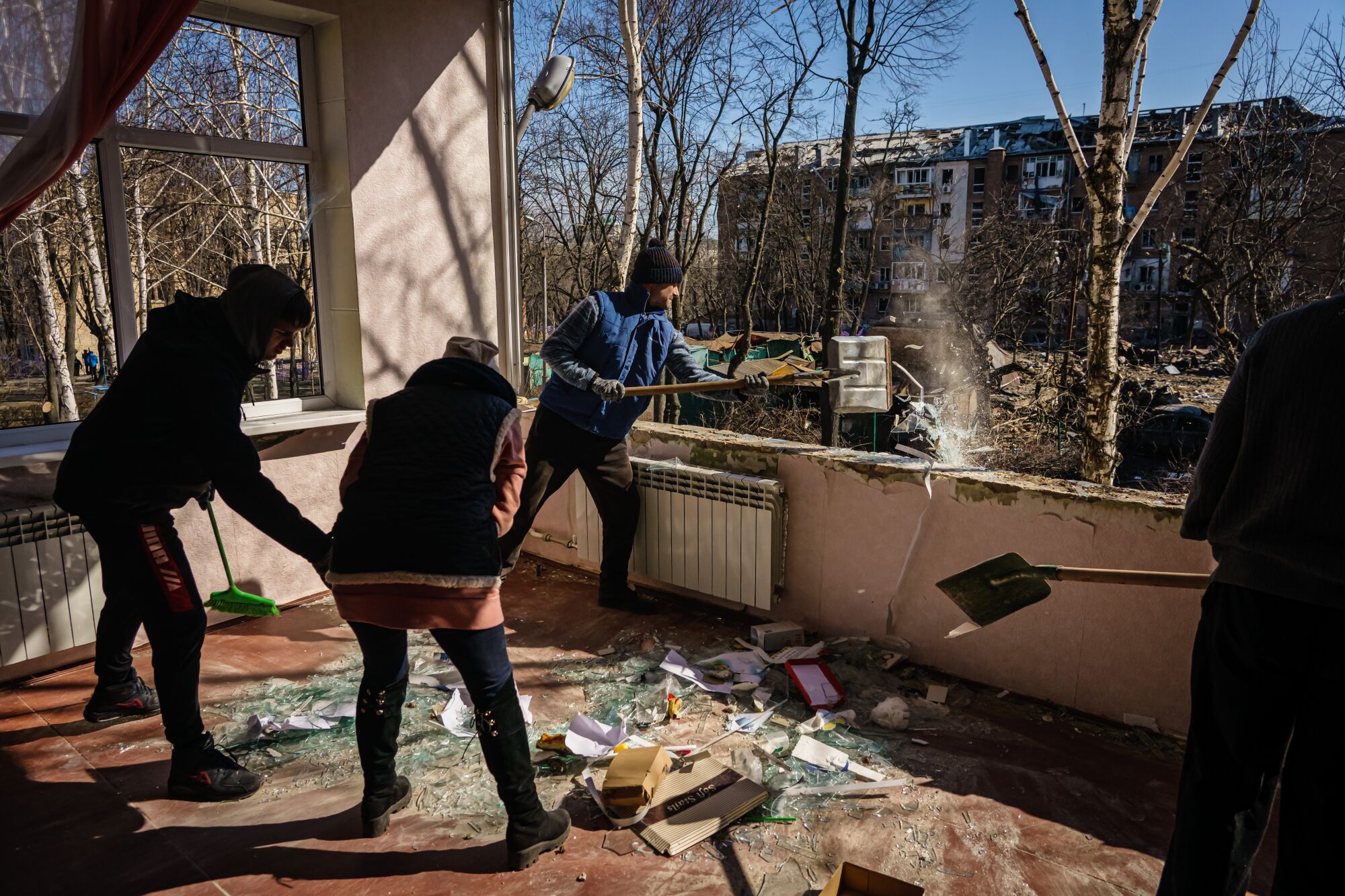 Voluntarios ayudan a limpiar una escuela infantil que se encontraba frente a la zona residencial atacada en Kyiv, Ucrania.