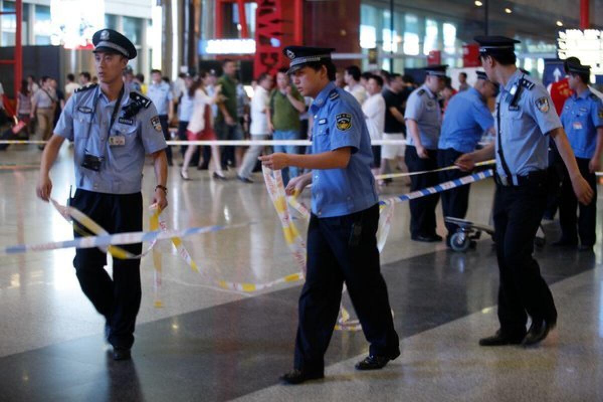 Police secure the Beijing airport after a man in a wheelchair detonated a homemade bomb June 20.