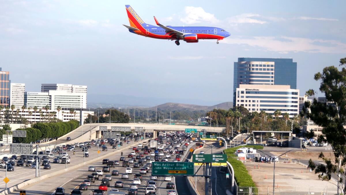A plane flies over the 405 Freeway as it approaches the John Wayne Airport runway in 2015.