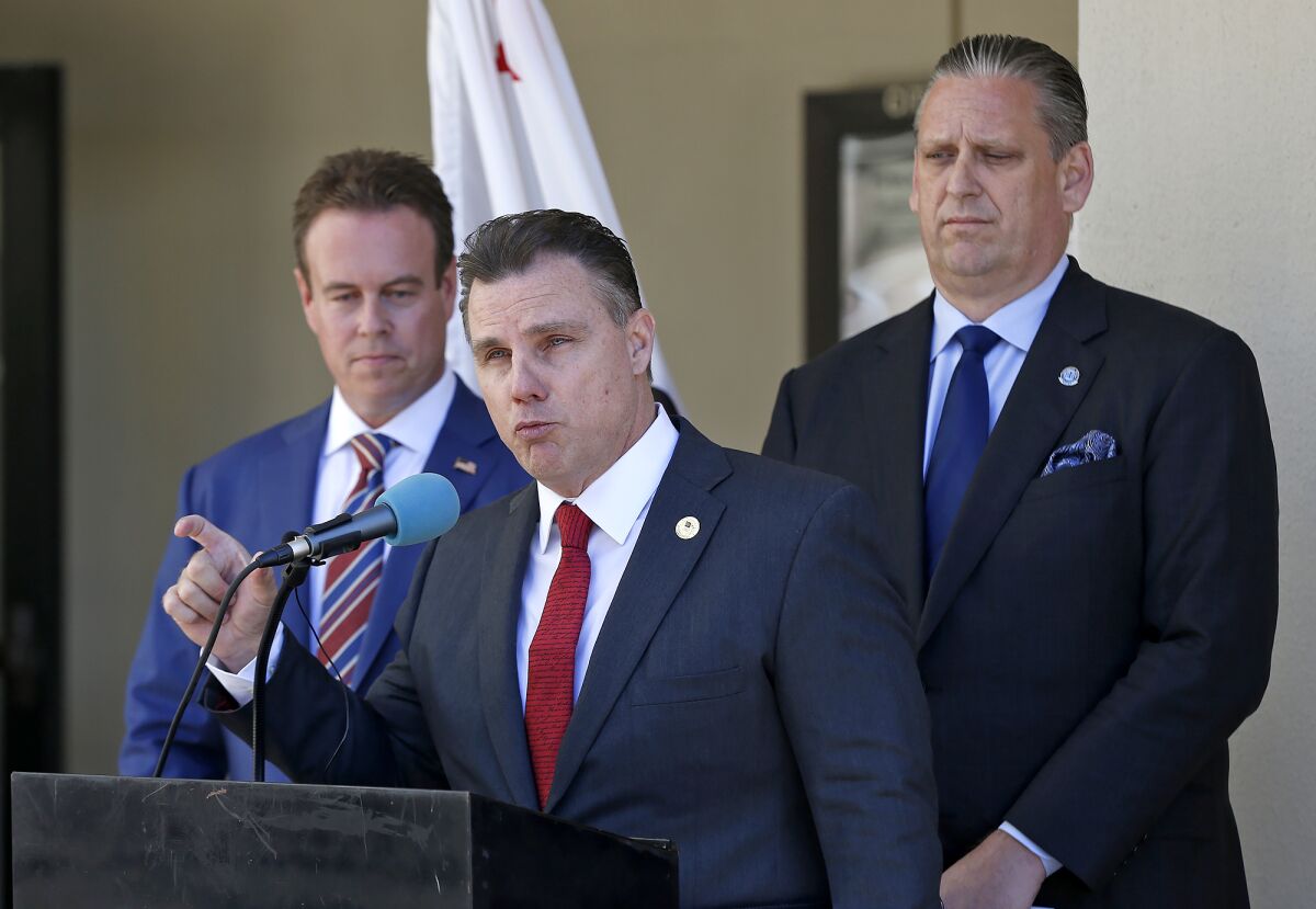 Huntington Beach City Atty. Michael Gates makes a point during a press conference Thursday.