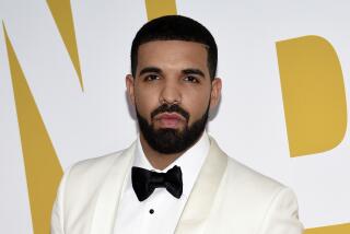 Drake wears a white tuxedo jacket and shirt and a black bow tie as he poses with a straight face