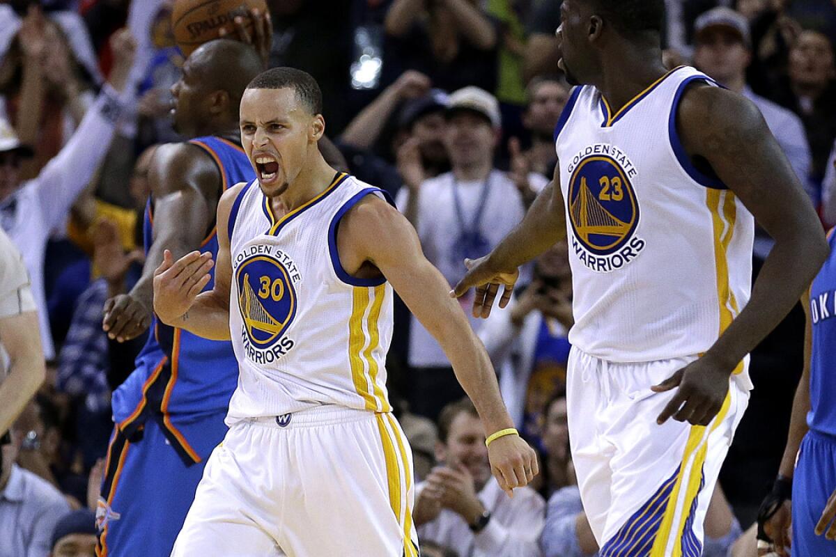 Warriors point guard Stephen Curry (30) celebrates with teammate Draymond Green (23) after scoring late in the game against the Thunder on Thursday night in Oakland.