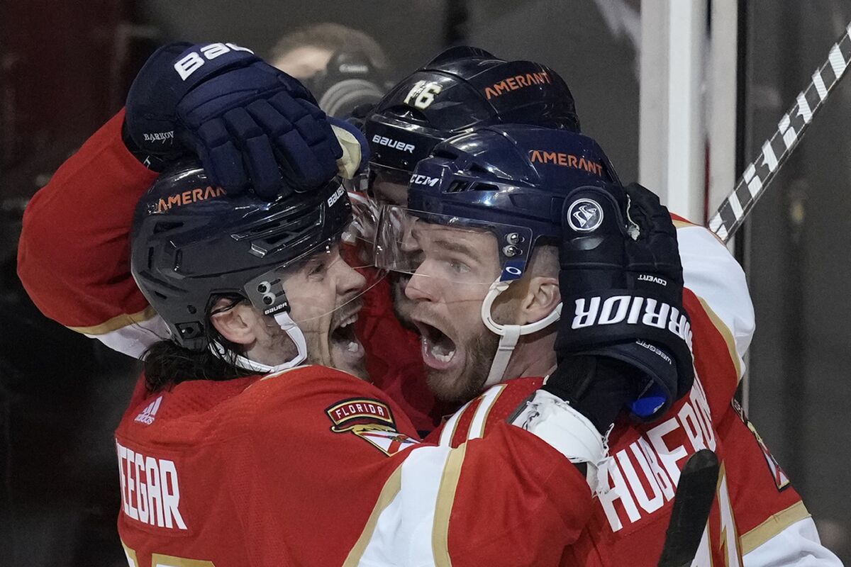 Florida Panthers left wing Jonathan Huberdeau, right, celebrates with teammates after scoring in overtime of the team's NHL hockey game against the Toronto Maple Leafs, Tuesday, April 5, 2022, in Sunrise, Fla. (AP Photo/Rebecca Blackwell)