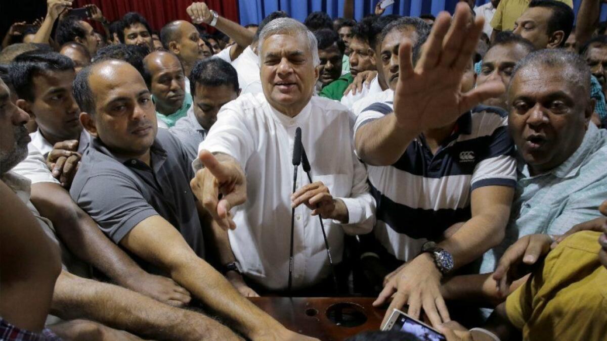 Sri Lanka's fired Prime Minister Ranil Wickeremesinghe, center, meets supporters at his official residence in Colombo.