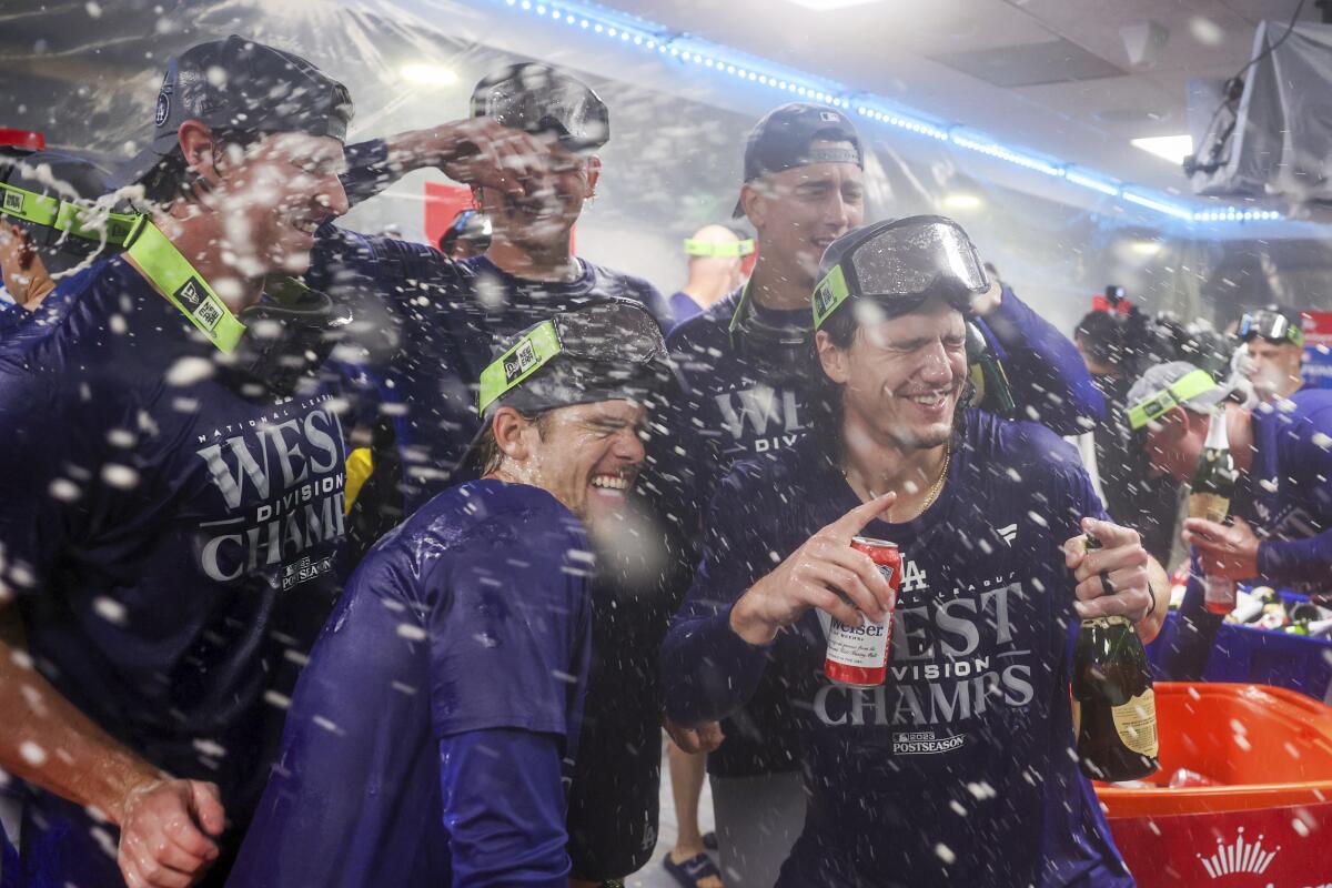 Dodgers players celebrate in the visiting team clubhouse at T-Mobile Park in Seattle.