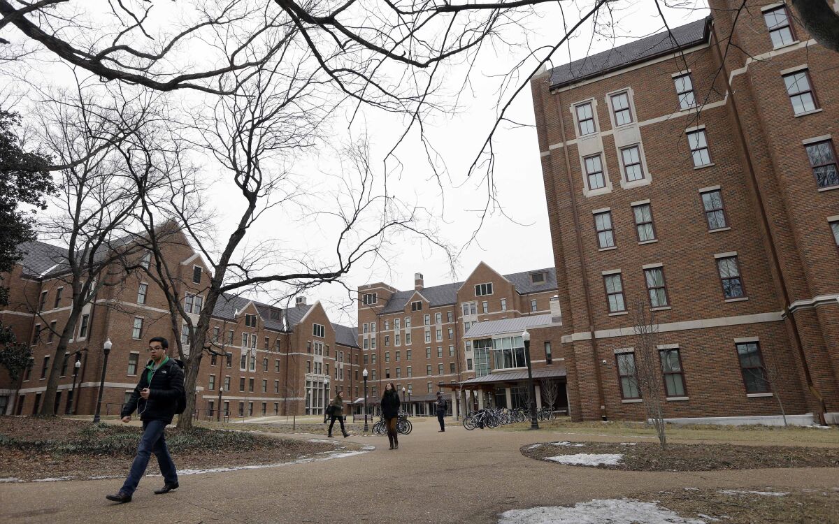 Students walk between buildings at Vanderbilt University on a grey, wintery day.
