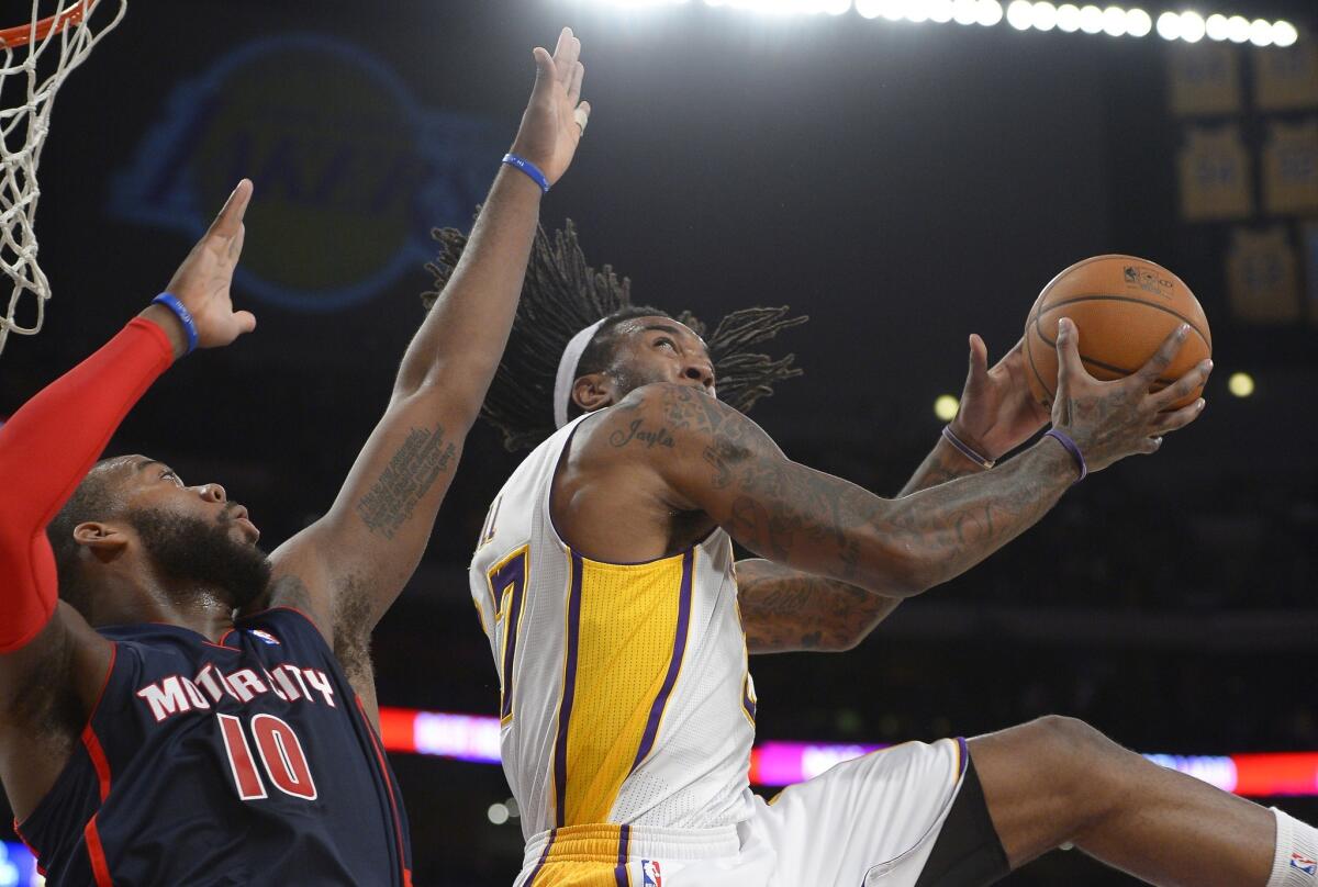 Lakers center Jordan Hill, right, puts up a shot over Detroit Pistons forward Greg Monroe during the first half of Sunday's game at Staples Center.