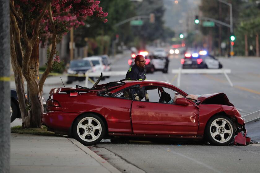 LA VERNE CA AUGUST 30, 2019 Ñ Work crews remove a red Acura from the scene of a double fatality accident on White Avenue in LaVerne Friday morning, August 30, 2019. The vehicle was being pursued by police in La Verne before slamming into a black Toyota Corolla near the intersection of White Avenue and College Lane Thursday evening. A total of three passengers in the two cars were hospitalized in critical condition. (Irfan Khan / Los Angeles Time)