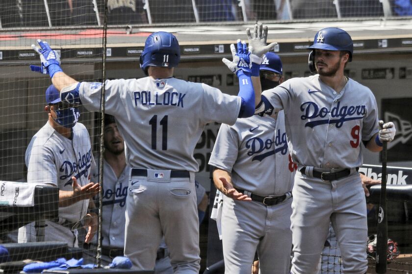 Los Angeles Dodgers' Gavin Lux, right, high-fives A.J. Pollock after Pollock hit a solo home run off San Diego Padres starting pitcher Adrian Morejon in the first inning baseball game Wednesday, Sept. 16, 2020, in San Diego. (AP Photo/Derrick Tuskan)
