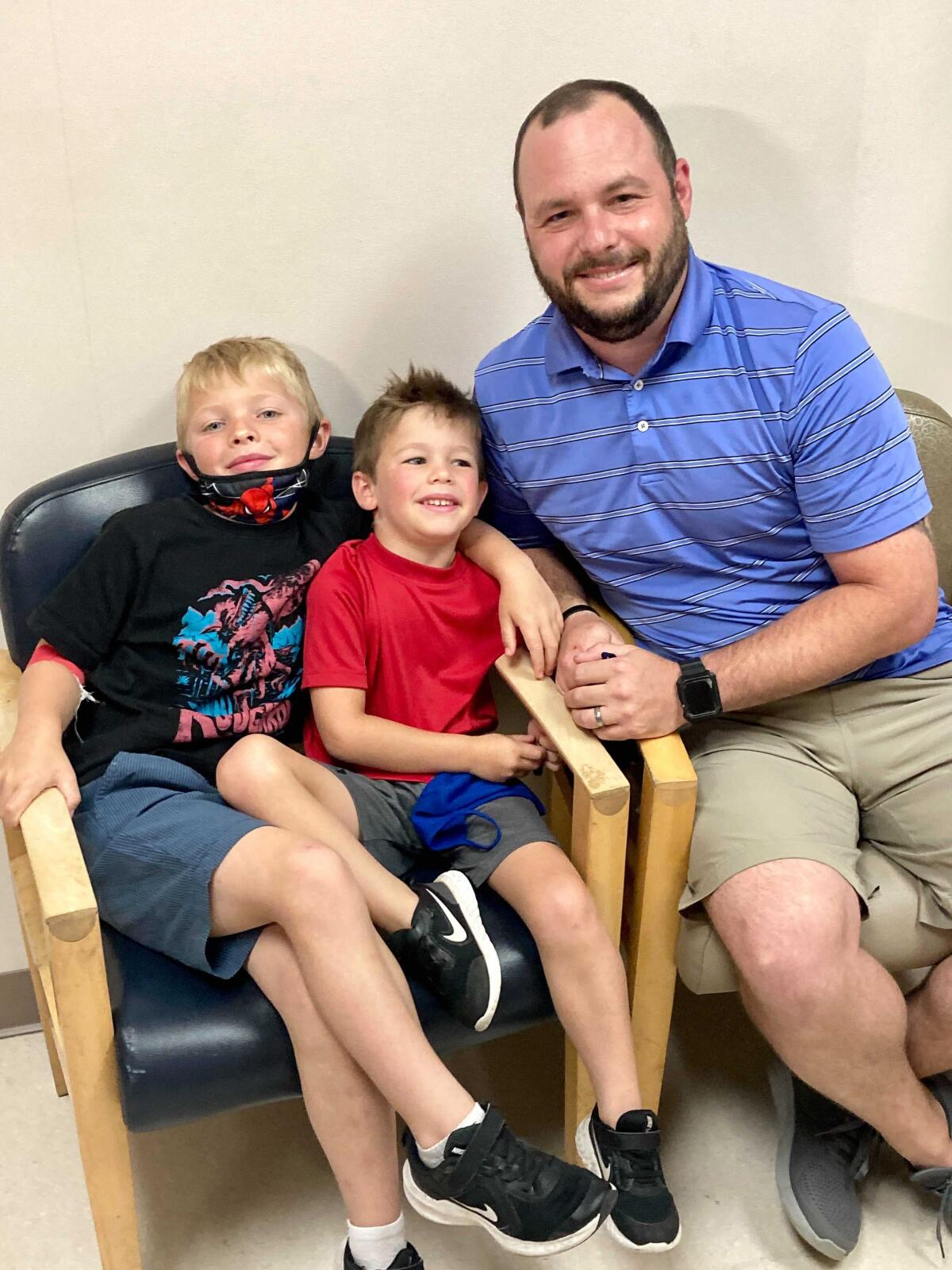 From left, 7-year-old Russell Bright, 5-year-old Tucker Bright, and dad Adam Bright pose for a picture at Ochsner Medical Center in Jefferson, La., Monday, June 7, 2021. Tests of Pfizer’s COVID-19 vaccine started Monday in Louisiana for children ages 5 through 11. (AP Photo/Stacey Plaisance)