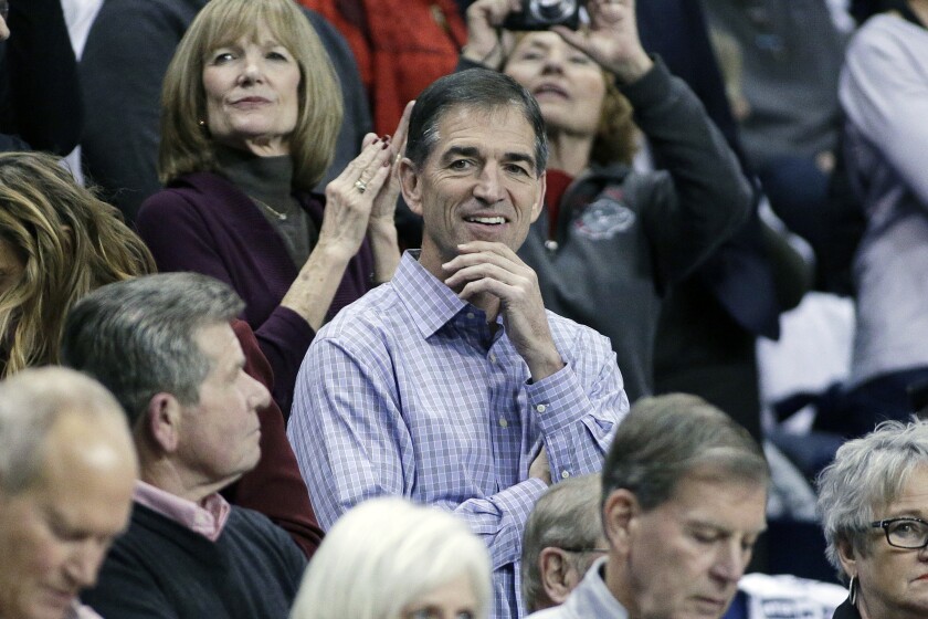 John Stockton, center, sits in the stands at a basketball game