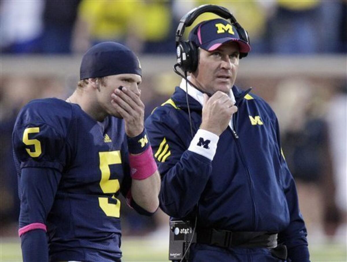 Michigan quarterback Tate Forcier (5) listens to head coach Rich Rodriguez during the closing minutes of an NCAA college football against Iowa in Ann Arbor, Mich., Saturday, Oct. 16, 2010. (AP Photo/Carlos Osorio)
