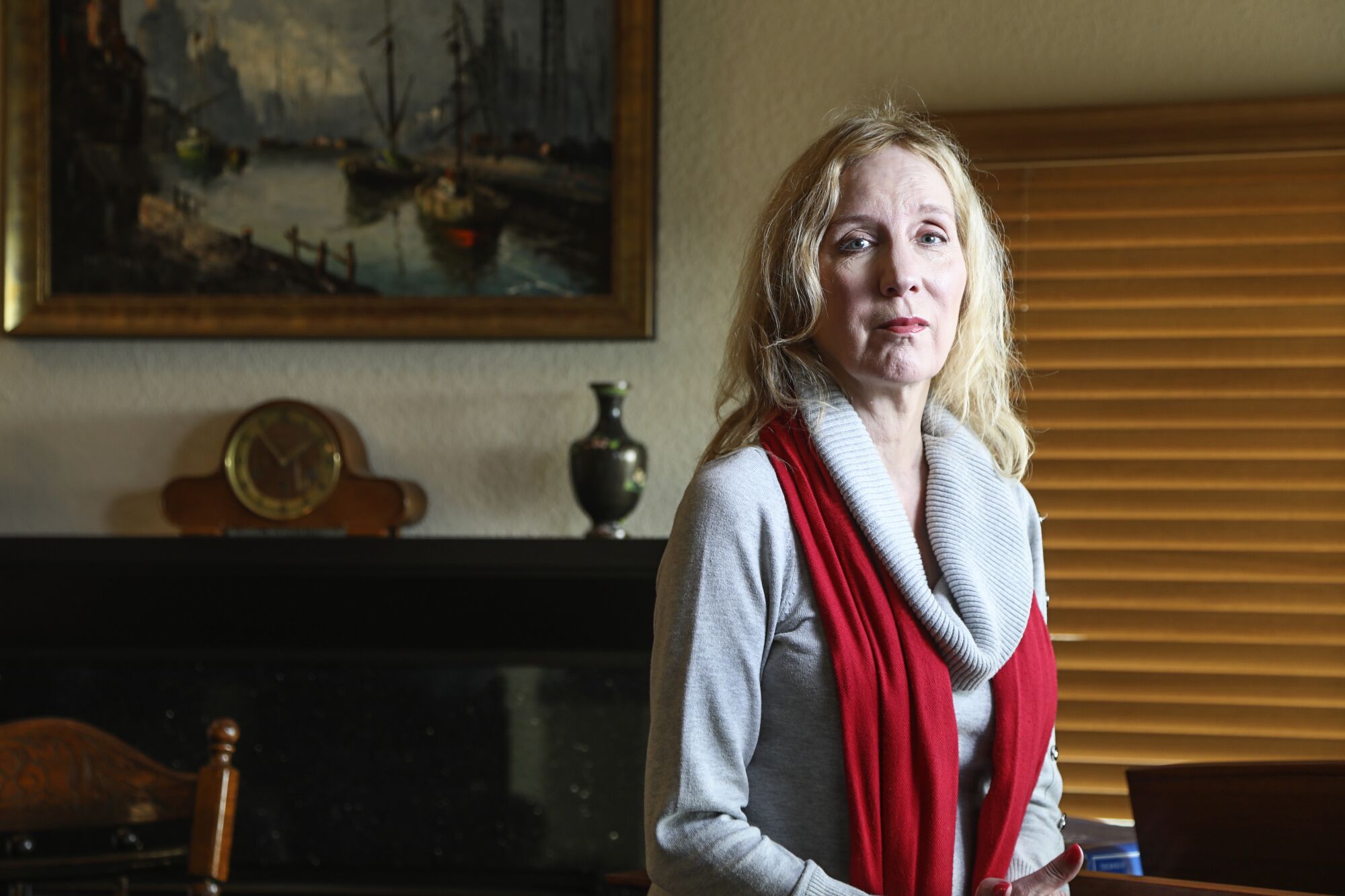 Cynthia Leigh poses for a photo at her home on March 18, 2020 in Tierra Santa, California. Her mother is at a senior living facility and she can only see her with a glass divider.