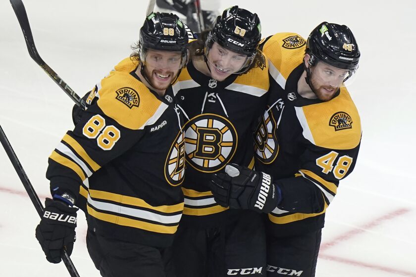 Boston Bruins right wing David Pastrnak (88) celebrates his goal with left wing Tyler Bertuzzi (59) and defenseman Matt Grzelcyk (48) during the second period of an NHL hockey game against the Montreal Canadiens, Thursday, March 23, 2023, in Boston. (AP Photo/Steven Senne)