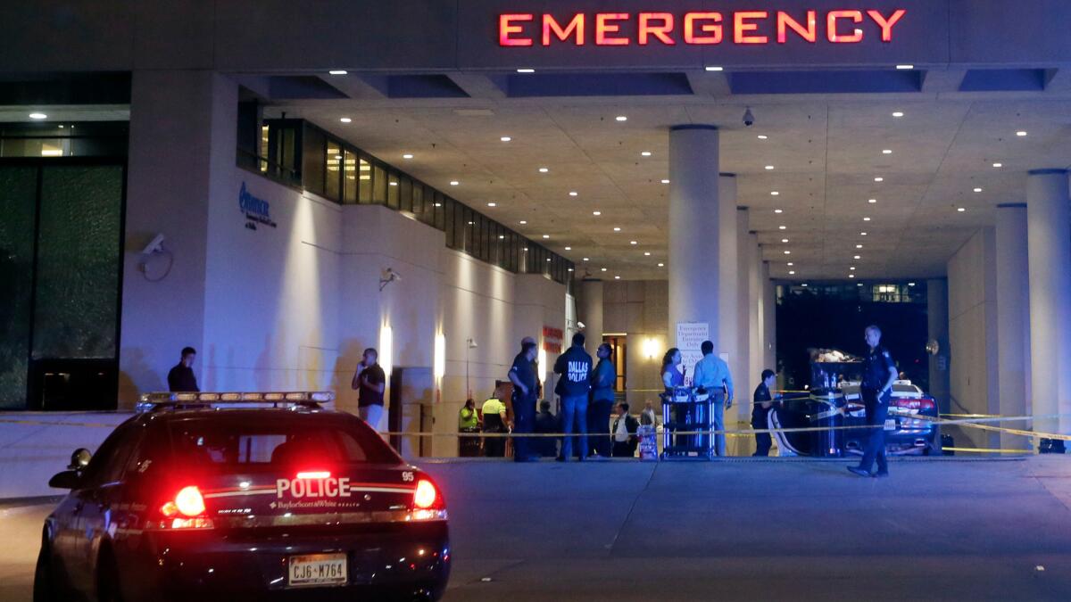 Law enforcement officers stand outside the emergency room at Baylor University Medical Center, early July 8.