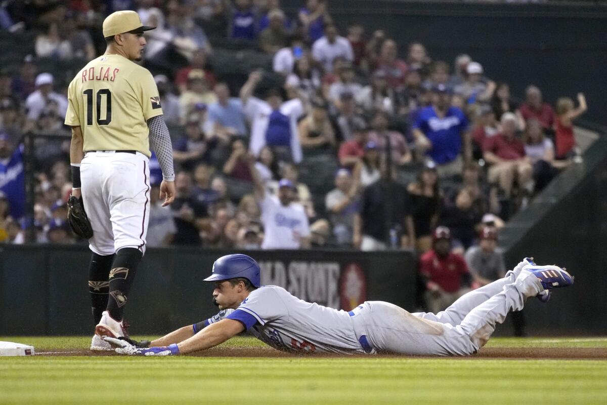 Dodgers shortstop Corey Seager slides into third after hitting a triple against the Diamondbacks.